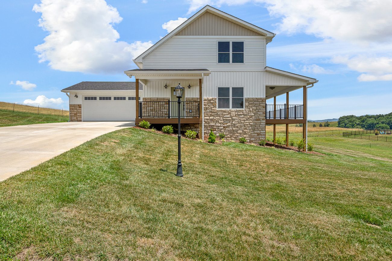Completed modern farmhouse with wraparound porch by Reliable Building Services