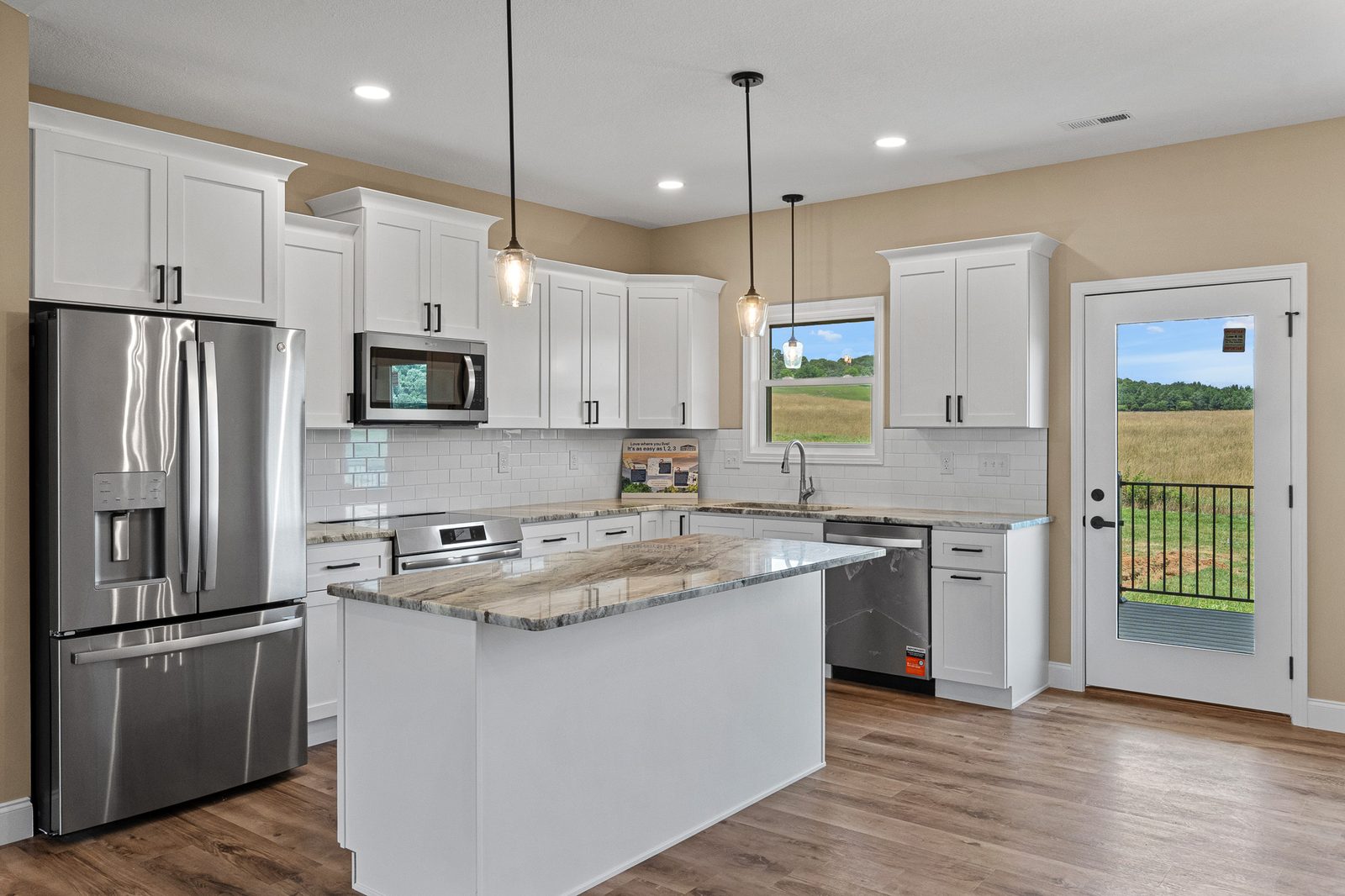 Kitchen with antique white shaker cabinetry, granite island, and stainless appliances